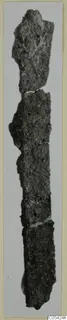 Corroded iron fragments, possibly tools, shown end to end in a vertical strip against a pale background