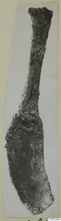 Corroded iron tool from Marion, a long narrow stem widening into a broad curved blade