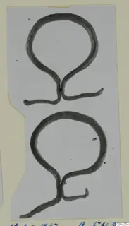 Two loop-shaped bronze mountings with tapering ends, shown on a pale card