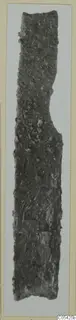 Corroded iron knife, long and narrow, with an encrusted, pitted surface