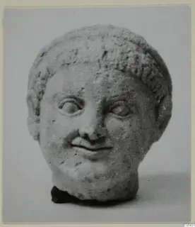 Terracotta limestone head from Mersinaki with short curled hair and a slight smile