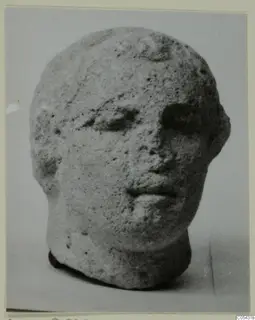 Limestone head from Mersinaki, shown three-quarter view against a plain background
