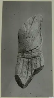 Limestone sculpture fragment, a broken torso-like piece with carved folds of drapery on the lower part