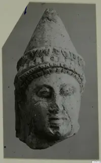 Limestone head with a tall conical headdress and a band of relief decoration, from Mersinaki