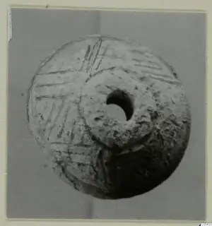 Spindle whorl of tufa from Marion Tomb 68, with incised lines on one face