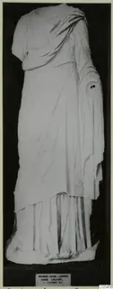 Marble statue of a standing draped woman from Salamis, head missing and one arm broken off at the shoulder.