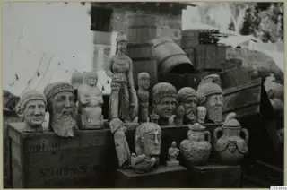 Display of sculpted heads, statues and vessels on wooden crates outdoors, at the Cyprus Museum