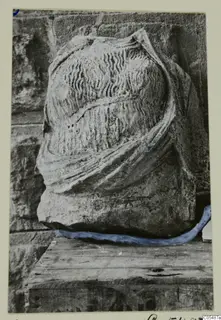 Carved stone fragment from Arsos, with wavy incised lines and a raised band of drapery across it