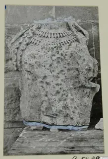 Stone statue from Arsos, shown in profile with carved ridged ornament across the top.