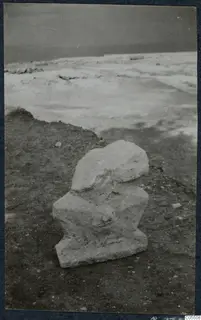 Weathered pale stone fragment lying in situ on dirt ground at Vouni Palace