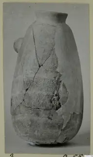 Pottery vessel from Amathus, tall with a flared rim and a small side handle, cracked and partly broken.