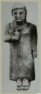 Limestone standing figure from Mersinaki in a long robe, one hand raised to the chest.