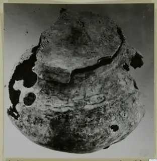 Corroded lead container with a broken lid, shown in close-up