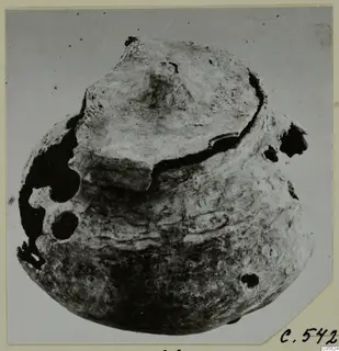 Corroded lead container with a raised lid, shown on a card mount