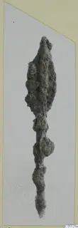 Corroded iron arrowhead from Marion, with a long tang, shown on a mounted photograph.