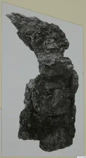 Heavily corroded iron object from Marion, irregular in shape with a pointed projection at the top.