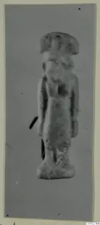 Small standing figure of Sekhmet, seen frontally against a grey background on a mounted print