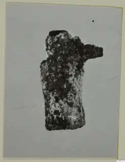 Small corroded object from Marion, Tomb 40 B, shown on a plain grey backdrop