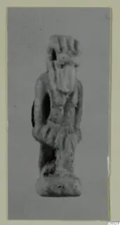 Small standing figurine with a tall headdress and a flat base, silver object from Marion Tomb 40 B