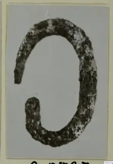 Silver ring, an open band with a tapering end, photographed on grey card