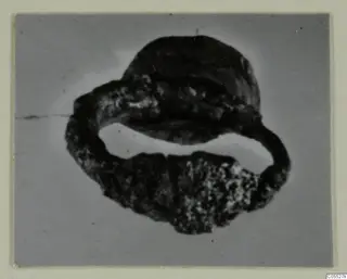 Silver ring from Marion tombs 31–45, seen at a steep angle against a plain grey background