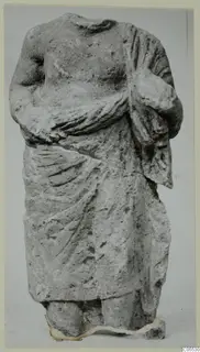 Headless draped stone statue from Mersinaki, shown frontally against a plain grey background.