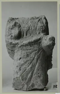 Limestone sculpture from Mersinaki showing a draped figure with worn, carved folds and a rounded projection at one side