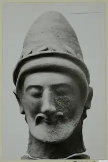 Terracotta head of a bearded man wearing a tall conical cap with leaf-like ornament, from Mersinaki