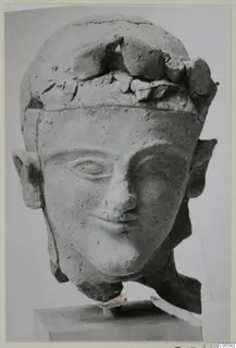 Head of a statue from Mersinaki with a band of raised shapes across the crown, shown from the front on a block base.
