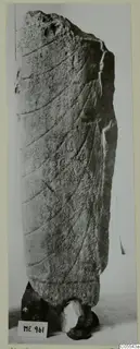 Tall limestone fragment from Mersinaki with shallow curved grooves, broken at the top, shown upright