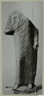 Limestone statue of a standing figure from Mersinaki, with incised lines on a long garment and a broken upper part