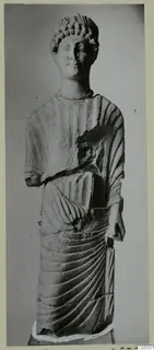 Limestone statue of a standing draped figure with a curled headdress, from Mersinaki