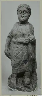 Standing draped figure from Mersinaki in grey terracotta limestone, on a rough irregular base