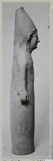Tall terracotta statue of a standing figure in side profile, facing right, with a tall flat-topped headdress.