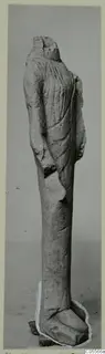 Standing limestone statue from Mersinaki, headless, wearing a long robe with vertical folds