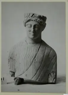 Limestone bust from Mersinaki with closed eyes, a curled headband and a draped garment