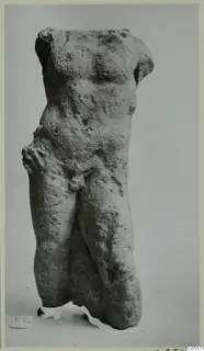Weathered stone torso of a standing male figure from Mersinaki, with head and arms missing