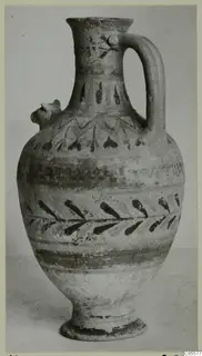 Pottery Polychrome III-VII jug with a strap handle, a small modelled projection on the shoulder and dark painted bands and leaves.