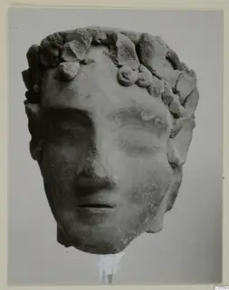 Head of a figure with a leafy wreath, from Mersinaki, photographed frontally.