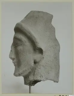 Fragment of a carved head in left profile, with a raised band across the top of the head