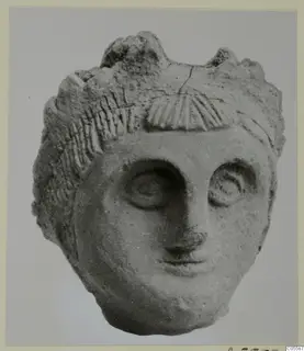 Terracotta head from Mersinaki, front view, with carved hair and a fan-shaped ridged ornament above the brow