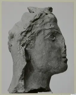 Carved stone head from Mersinaki, shown in profile facing right, broken at the top and back.