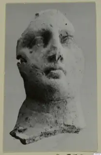 Head fragment from Mersinaki with face and neck, photographed against a plain grey background