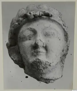 Terracotta head from Mersinaki with a rounded face and a thick band across the top of the head