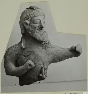 Terracotta figurine of a bearded male bust with one arm raised to the right and the other fist at the chest
