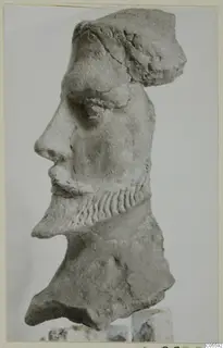 Carved stone head in profile with a curled beard, from Mersinaki