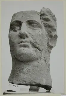 Stone head from Mersinaki, shown front-on, with the top and right side of the hair broken away.