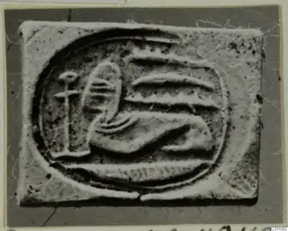 Glyptic: a rectangular seal with a raised design of a reclining form and a vertical stem inside an oval border