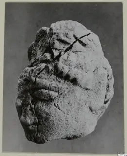 Limestone sculpture fragment from Mersinaki, with carved relief forms and a diagonal crack across the surface.