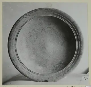 Pottery bowl seen from above, with two concentric grooves on its wide rim and a small number label at lower right